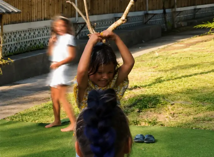 Outdoor Kids Team Play Activity Children playing a fun outdoor balance and water game on a grassy playground area